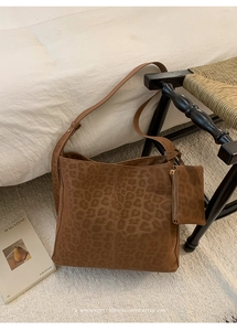 Macro view of vintage leopard print tote bag texture with matching mini zipper pouch