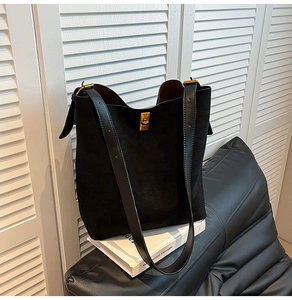 Dettaglio ravvicinato della borsa tote in pelle scamosciata nera con fibbia dorata
