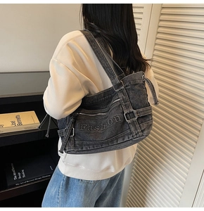Detail of grey washed denim shoulder bag featuring Fashion embroidery and workwear straps