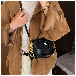 Détail du sac oreiller tissé noir avec écusson de chiot et accessoire de charme chocolat