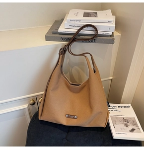 Detail of large canvas tote bag with brown leather straps on minimalist background