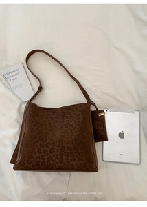 Detail view of large leopard print bucket bag with matching mini pouch and wide strap