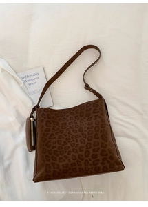 Detail of leopard print faux suede bucket bag with a matching mini zipper pouch accessory