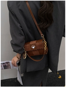 Detail of vintage brown PU leather crossbody bag with patchwork suede and dog logo