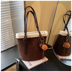 Detail of faux fur trim and matte leather finish on a vintage brown bucket bag