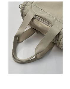 Detailed macro view of the reinforced stitching and smooth zipper on this nylon tote bag