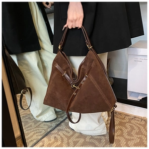 Detailed view of dark brown suede tote bag with geometric design and metal buckle