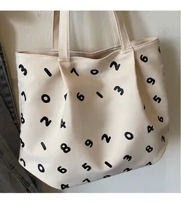 Close-up of beige canvas tote bag featuring black numeric prints and sturdy carry handles