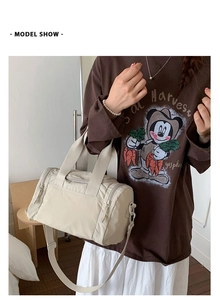 Vista dettagliata della borsa a cilindro in nylon beige con tasche a zip e tracolla regolabile