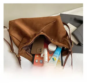 Interno spazioso della borsa tote in pelle scamosciata marrone con tablet e trucchi