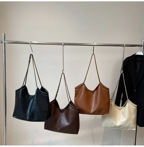 Detailed display of four large tote bags in black brown camel and cream with chain straps