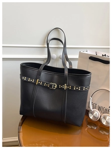 Detail of black lychee grain tote bag with gold rivets and leather buckle decor
