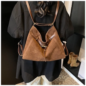 Detail view of the large brown suede hobo bag with leather straps and gold buckle