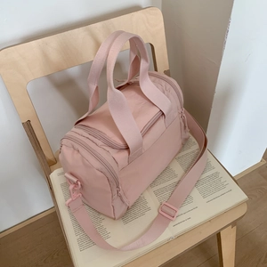 Dettaglio del borsone sportivo cilindrico in nylon rosa con tracolla regolabile