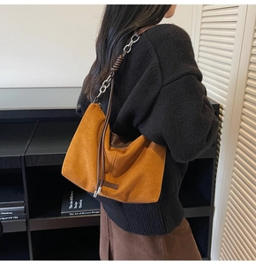 Caramel faux suede shoulder bag with chain strap detail shown on a female model