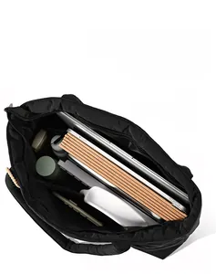 Top view of large black quilted nylon tote bag interior showing laptop and books