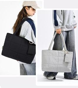 Detail view of quilted tote bags in black and light grey with matching round straps