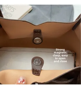 Detalle del cierre magnético fuerte en el bolso de gamuza marrón tipo cubo