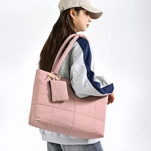 Detailed side view of the large quilted dusty rose shoulder bag with mini pouch detail