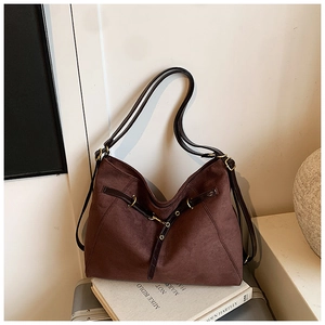 Dettaglio di una grande borsa tote in pelle scamosciata marrone scuro con finiture dorate