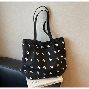Detail of minimalist black canvas tote bag with white numeric pattern and spacious opening