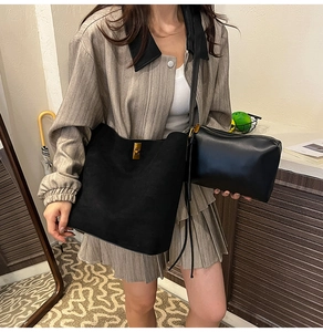 Dettaglio della borsa shopper nera con chiusura a scatto in ottone e pochette coordinata