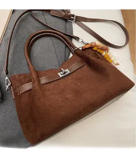 Detalle del bolso de hombro en ante marrón oscuro con hebilla plateada y adorno de cuentas