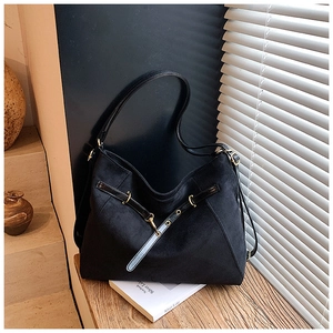 Dettaglio borsa hobo in pelle scamosciata nera con fibbie in metallo dorato e luci d'ombra