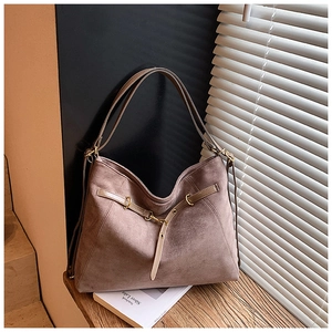 Dettaglio della borsa tote in pelle scamosciata con cinturini e fibbia dorata