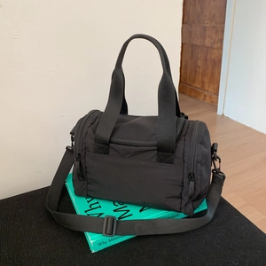 Detailed view of the black nylon duffel bag with reinforced handles and adjustable strap