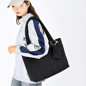 Detail of black quilted nylon tote bag with matching mini pouch and shoulder strap