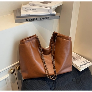 Detailed view of the brown leather tote bag with vintage metal chain straps
