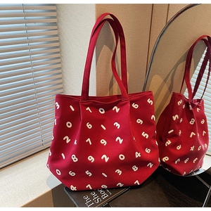 Detail of red canvas tote bag with white number prints and double shoulder straps