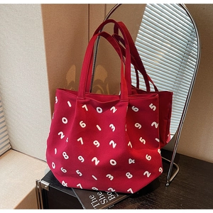 Detail of red canvas tote bag with white number print and durable fabric texture