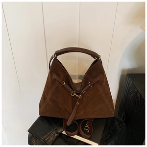 Detail of dark brown suede hobo bag with gold metal buckle and textured matte finish