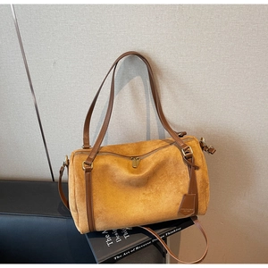 Dettagli della texture opaca e cuciture in pelle bicolore sulla borsa Boston
