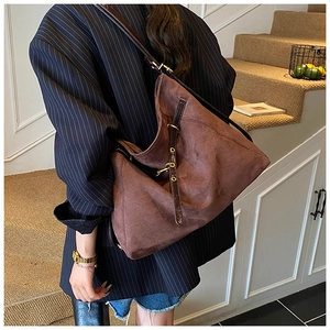 Dettaglio della grande borsa tote in pelle scamosciata marrone con cinturino in pelle