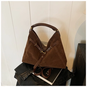 Detailed close-up of dark brown suede tote bag featuring golden hardware and leather straps