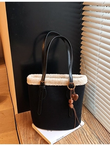 Fuzzy black tote bag with white fleece trim and heart pendant in stylish sunlight
