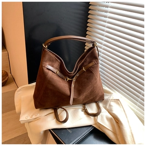 Detailed view of dark brown suede tote bag featuring smooth leather straps and gold hardware