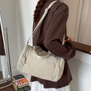 Vista laterale dettagliata di una borsa tote in tela color crema con tracolla regolabile