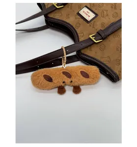Detail of cute baguette plush charm with beaded strap on brown large tote bag