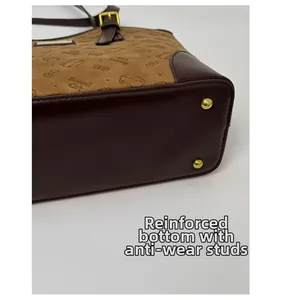 Detail view of the thickened bottom and gold protective metal studs on the brown tote bag
