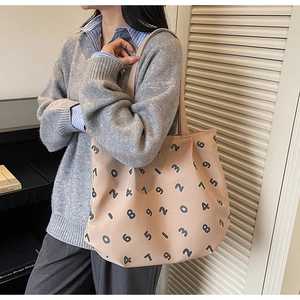 Detail of a large canvas tote bag with black numeric prints for daily commute
