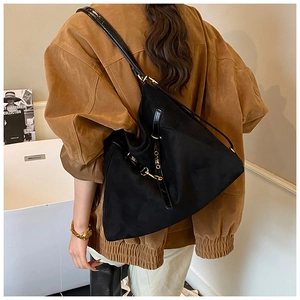 Vista posteriore di una modella con una borsa tote nera minimalista e fibbie in metallo