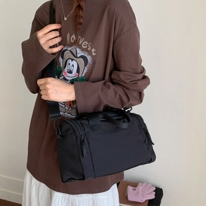Dettaglio della borsa tote in nylon nero con doppi manici e tracolla regolabile sportiva