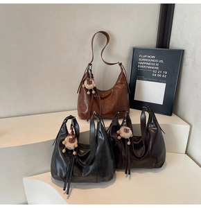Detailed display of vintage large capacity moon bags in brown and black with tassels