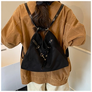 Vista dettagliata di uno zaino nero con spallacci in pelle a contrasto indossato da una modella