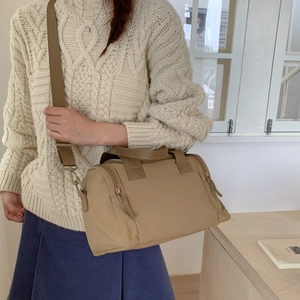 Dettaglio della borsa tote beige in nylon con tracolla regolabile e chiusura a zip