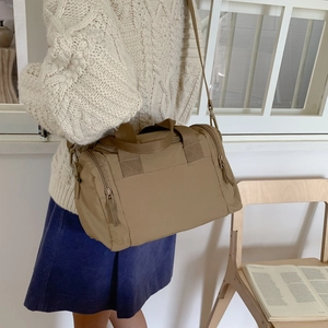 Dettaglio della borsa tote in nylon kaki con tasche laterali e tracolla in tessuto